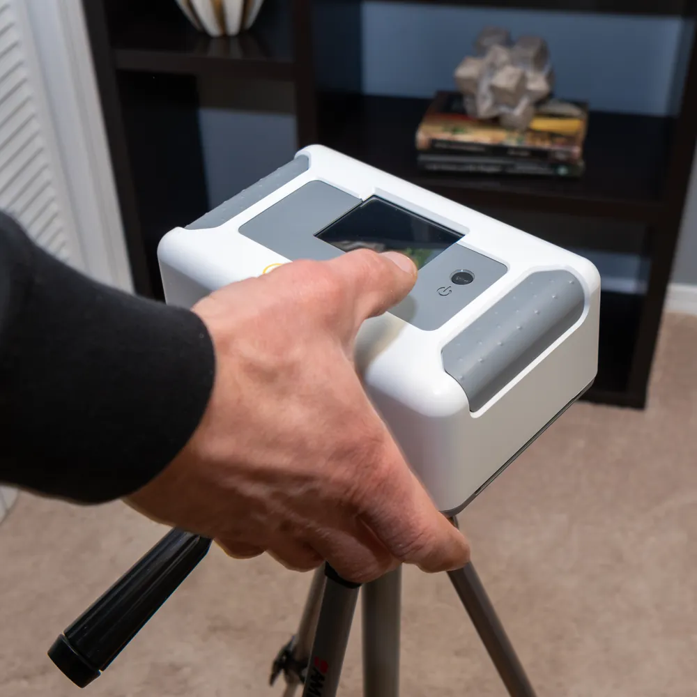 Continuous radon monitor on a tripod being started in a home